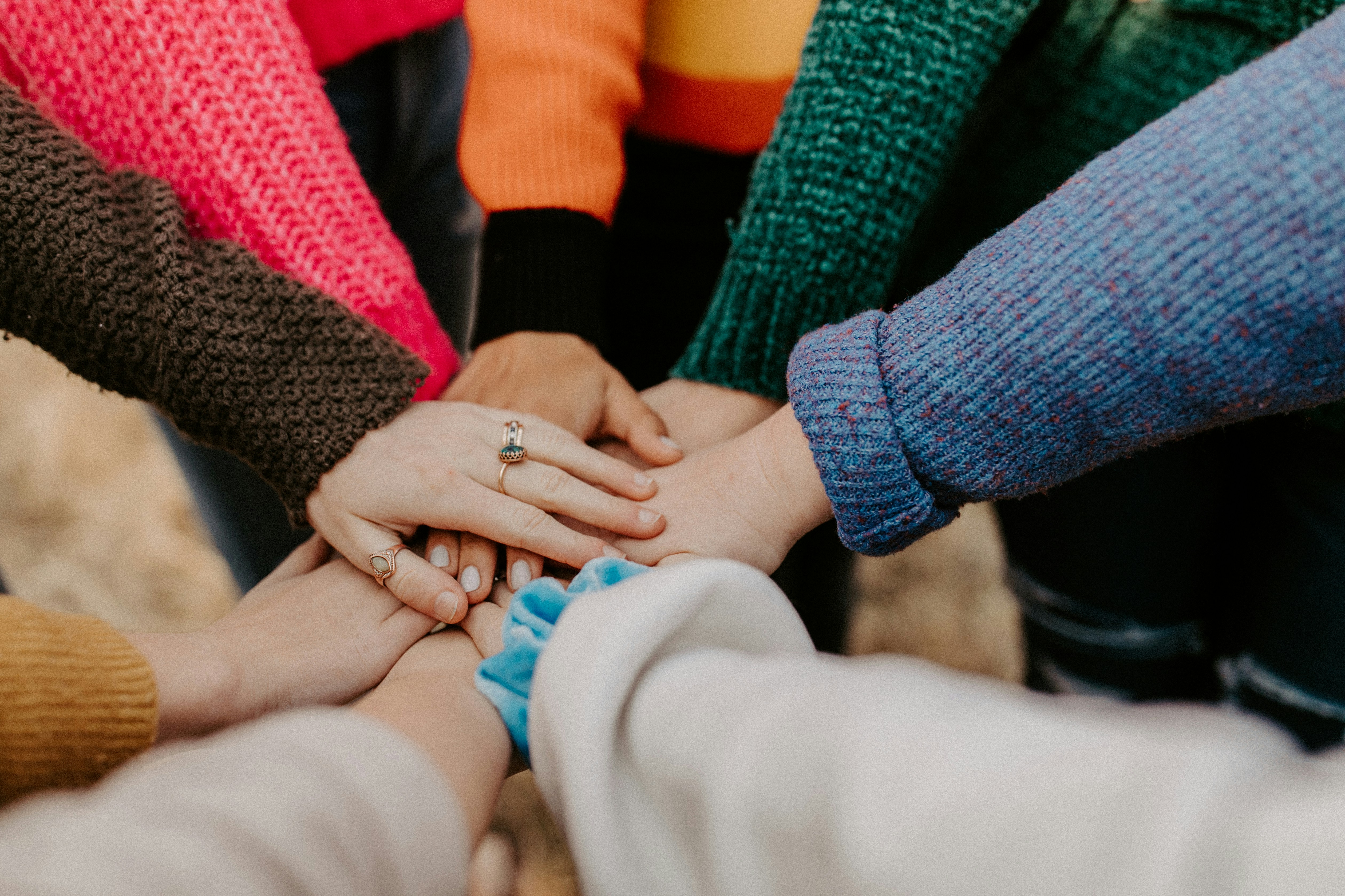 a group of people putting their hands together